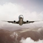Passenger jet airplane flying above clouds